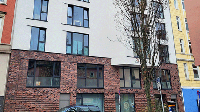 modernes mehrstöckiges Gebäude, Fassade Erdgeschoss braun, die weiteren Etagen in weiß