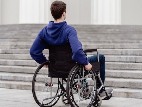 Rollstuhlfahrer vor Treppe