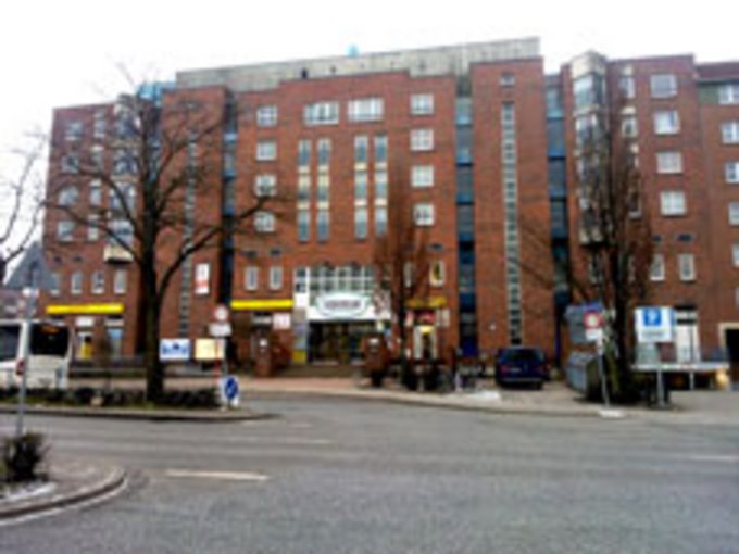 mehrstöckiger Backsteinbau mit Balkons zur Straßenseite