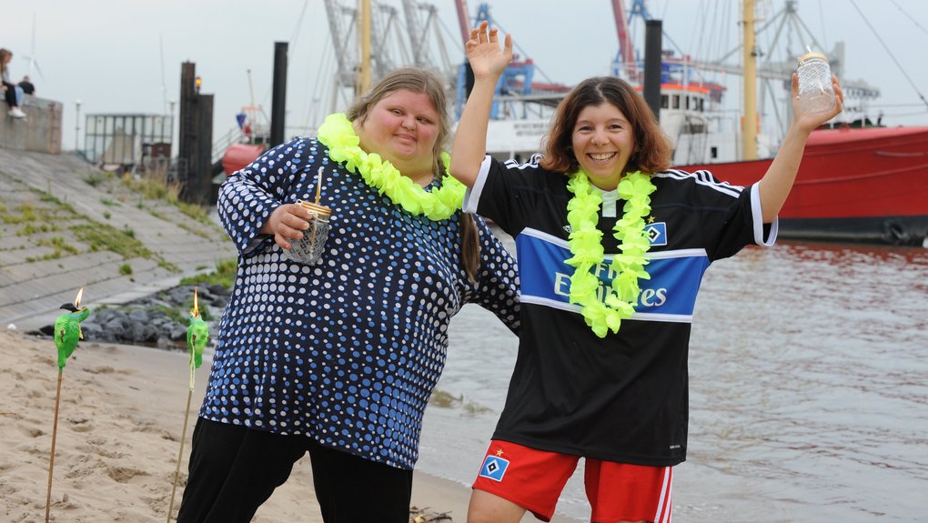 Zwei Frauen stehen vor einem Schiff am Hafen